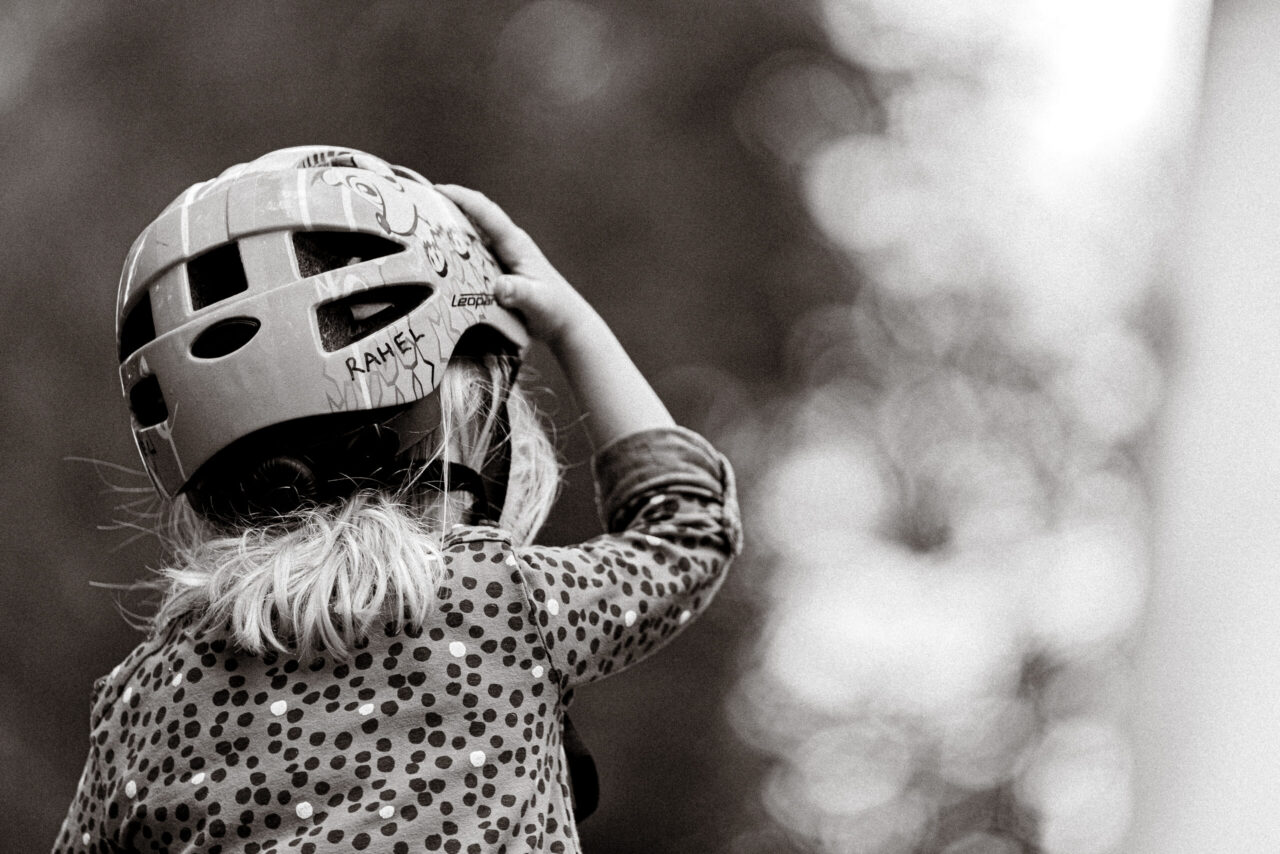 A child adjusting a riding helmet