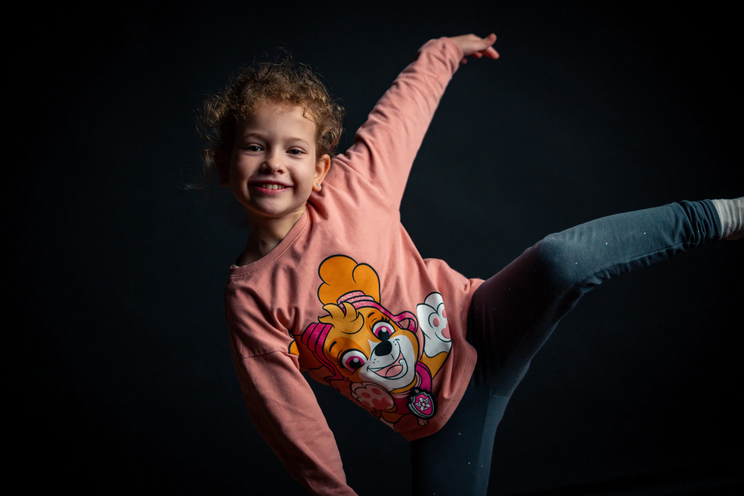 A child dancing in a dark studio