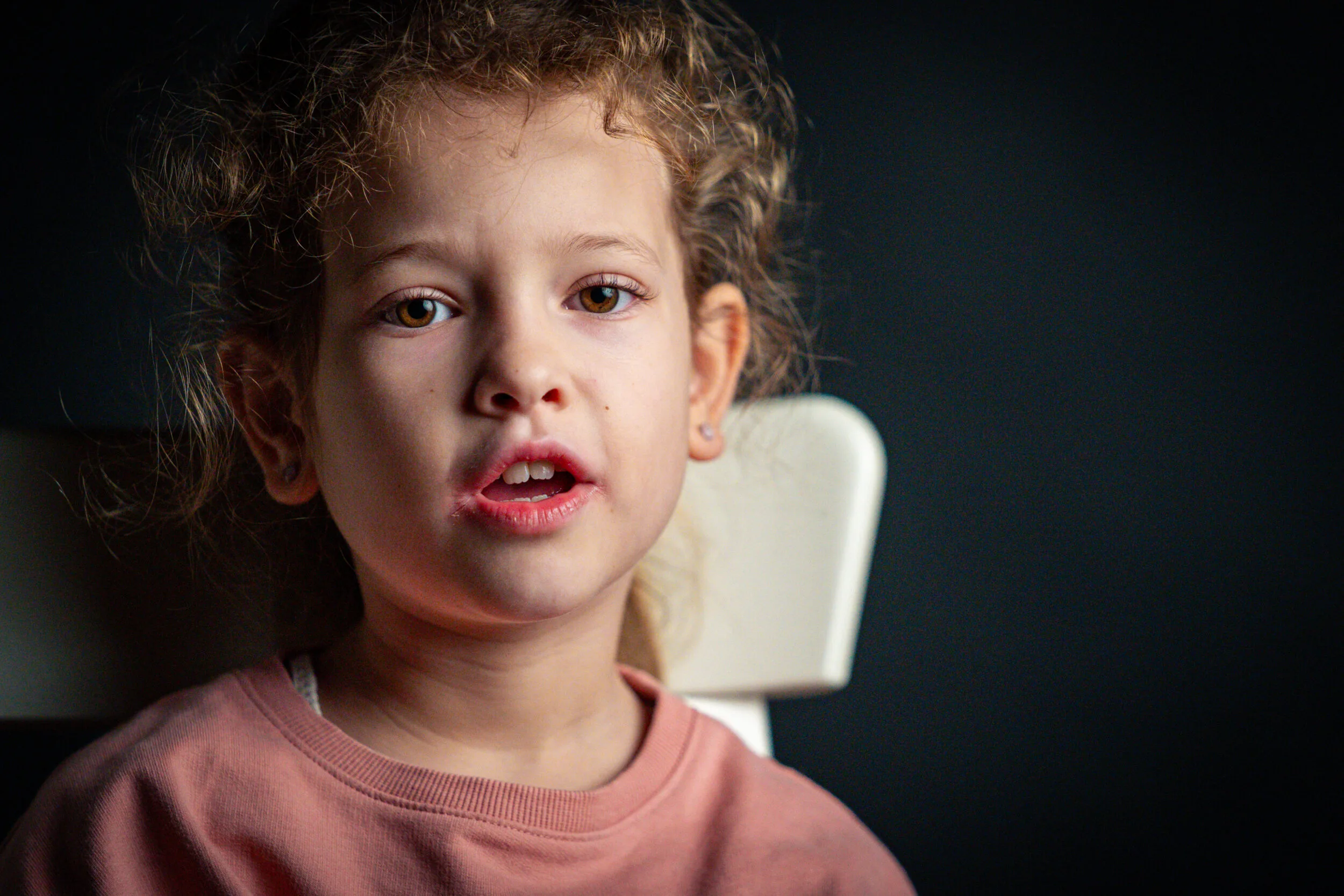 A child portrayed against a dark background